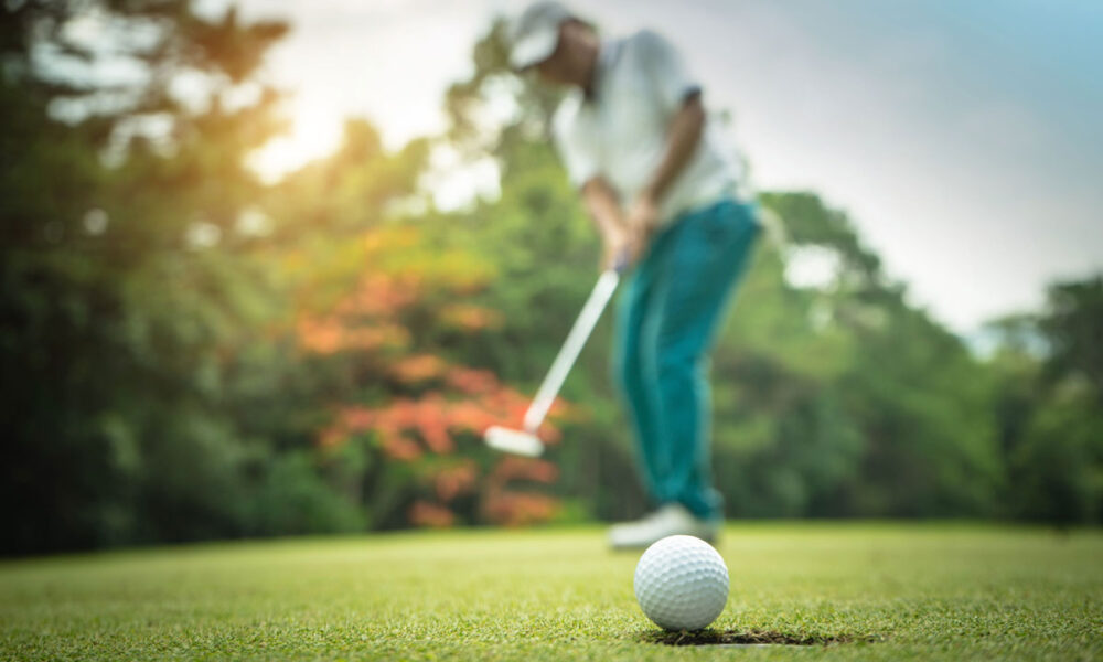 Golfer practicing putting and chipping on a green for short game improvement